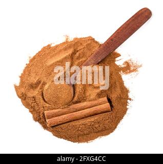 top view of wood spoon on pile of cassia bark and cinnamon powder on white background Stock Photo