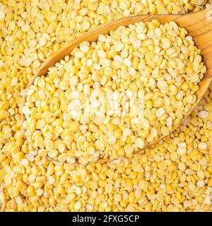 top view of raw moong dal (split green mung) beans in wooden spoon closeup Stock Photo