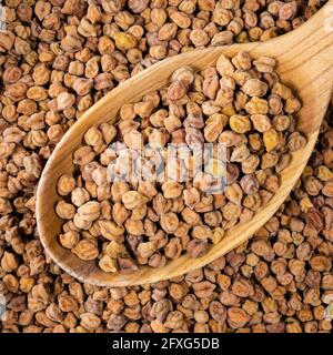 top view of raw black chickpeas in wooden spoon closeup Stock Photo