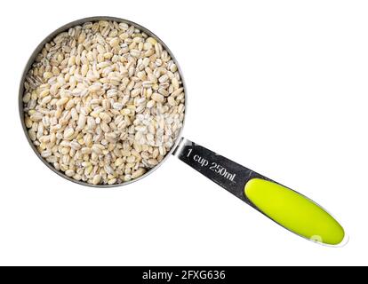top view of raw pearl barley groats in measuring cup cutout on white background Stock Photo