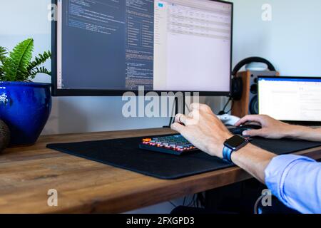 Hands typing on keyboard at a tropical office desk Stock Photo