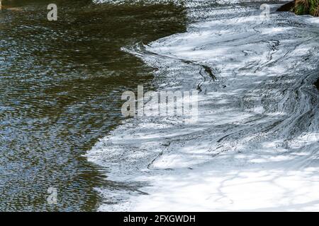 Water pollution in a river flowing from an old disused lead mine in Wales after passing through a water treatment plant Stock Photo