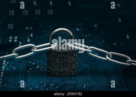 locked padlock with chain on computer motherboard Stock Photo