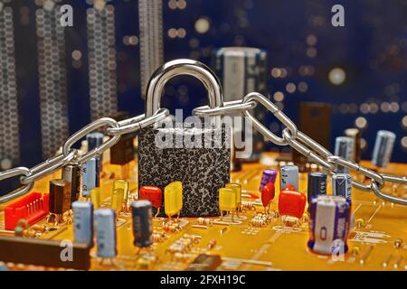 closeup of circuit board with various radio parts mounted on it and locked padlock with chain Stock Photo