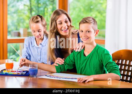 Mother with kids painting pictures with water color Stock Photo