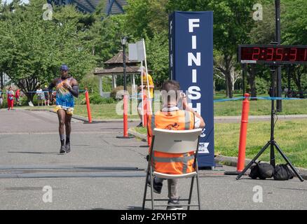 The official race photographer takes a snap of a male finisher approaching the end of the NYCRuns Queens half marathon in Flushing Meadows Corona.Th Stock Photo