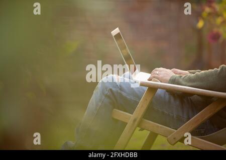 Man using laptop in garden Stock Photo
