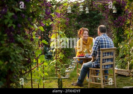 Happy couple enjoying champagne in idyllic summer garden Stock Photo