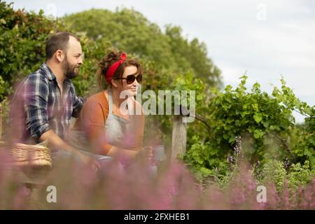 Couple relaxing with tea on sunny summer bench Stock Photo