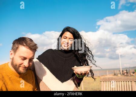 Couple eating on sunny beach patio Stock Photo