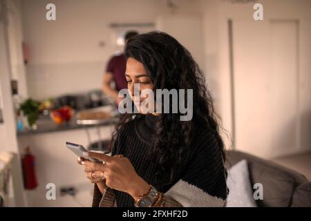 Woman using smart phone at home Stock Photo
