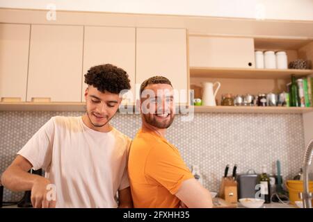 Portrait happy gay male couple in kitchen Stock Photo