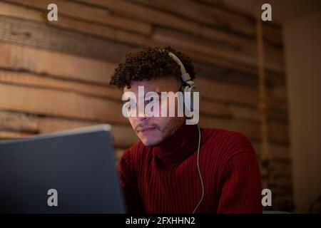 Focused young man with headphones using digital tablet Stock Photo