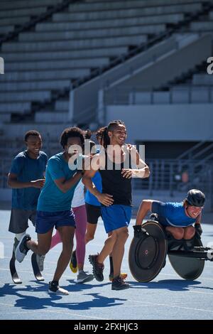 Happy athletes on sunny sports track Stock Photo
