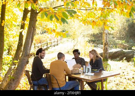 Creative business team meeting at table in sunny idyllic autumn park Stock Photo