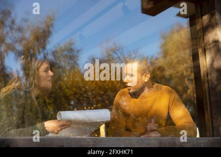 Business people discussing paperwork at sunny cafe window Stock Photo