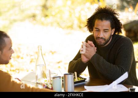 Businessmen discussing paperwork over lunch in park Stock Photo