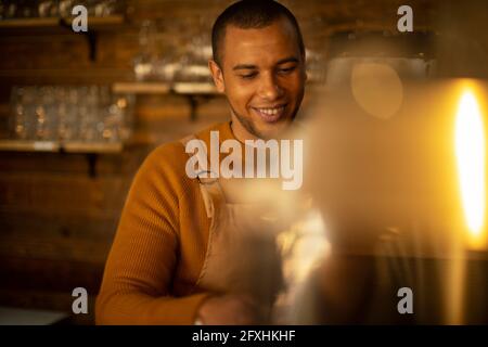 Smiling male barista preparing coffee in cafe Stock Photo