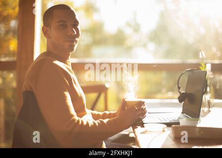 Portrait confident businessman with hot coffee working in cafe Stock Photo