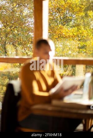 Businessman with paperwork working in sunny autumn cafe Stock Photo