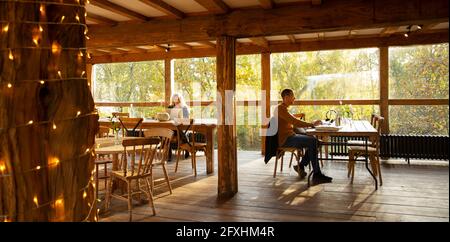 Business people working at laptops in autumn cafe Stock Photo