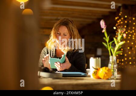 Businesswoman using smart phone at cafe table Stock Photo