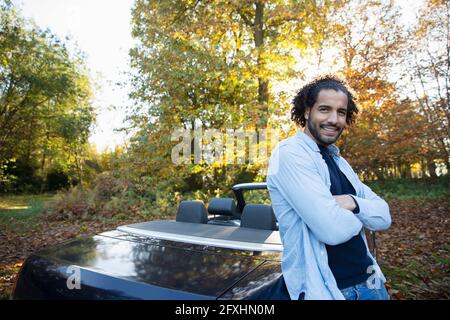 Portrait happy man at convertible in autumn park Stock Photo