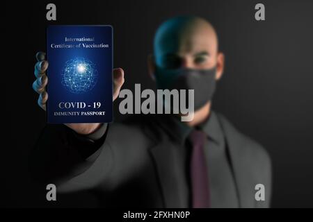 Businessman in face mask with COVID-19 immunity passport Stock Photo