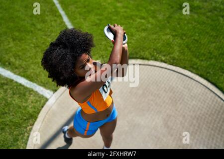 Female track and field athlete throwing discus Stock Photo