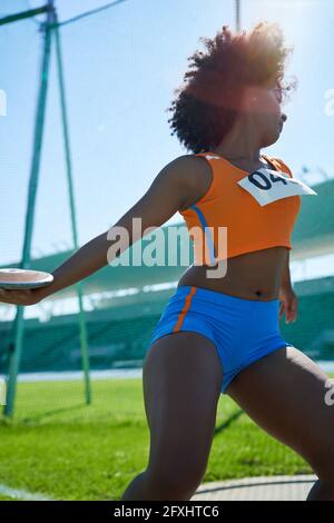 Female track and field athlete throwing discus Stock Photo