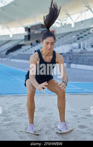 Female track and field athlete long jumping Stock Photo
