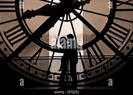 FRANCE, PARIS (75) 7TH ARR, A COUPLE OF LOVERS KISSING IN FRONT OF THE BIG CLOCK OF THE ORSAY MUSEUM Stock Photo