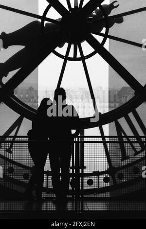 FRANCE, PARIS (75) 7TH ARR, A LOVING COUPLE LOOKING AT THE SEINE IN FRONT OF THE BIG CLOCK OF THE ORSAY MUSEUM Stock Photo