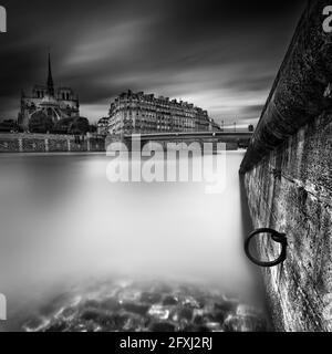 FRANCE, PARIS (75). 4TH ARR. VIEW OF THE CATHEDRAL OF NOTRE DAME DE PARIS FROM THE QUAYS OF ORLEANS WITH A RING ON THE WALL IN THE FOREGROUND (BEFORE Stock Photo