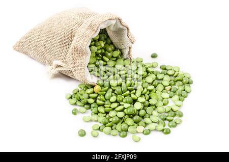 organic green split peas filling in sack bag on a white background. Stock Photo
