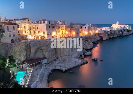 Illuminated pool of luxury resort by the sea at dusk in Vieste old town, Foggia province, Gargano, Apulia, Italy, Europe Stock Photo