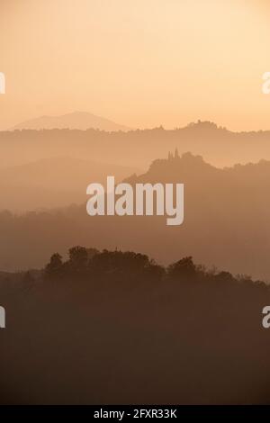 Sunset light reflected in the mist on countryside hills, Emilia Romagna, Italy, Europe Stock Photo