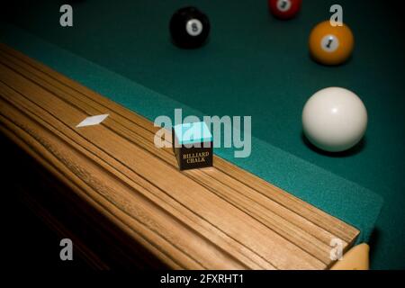 Close up shot of billiard chalk on pool table with balls in background Stock Photo