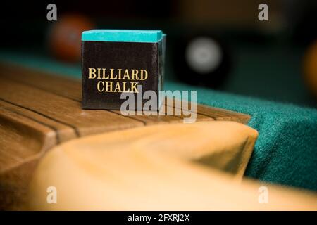 Close up shot of billiard chalk on pool table with balls in background Stock Photo
