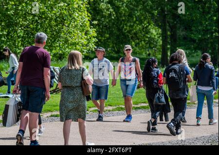 London, UK. 27th May, 2021. The sun finally appears and the weather begins to warm up after a period of unseasonably cold and wet May weather. People come out to enjoy it and their lunch in Green Park London. Credit: Guy Bell/Alamy Live News Stock Photo