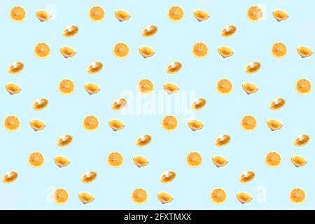 Bright colorful repetitive pattern made of lemon pieces on blue background. Minimal abstract concept flatlay . Stock Photo