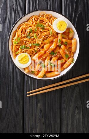 Rabokki is a type of tteokbokki with added ramyeon noodles it is a Korean street food closeup in the bowl on the table. Vertical top view from above Stock Photo