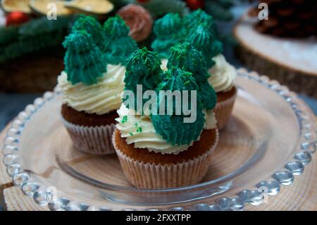Holiday muffins with winter motives. White and green creamy cream. Christmas cake. Stock Photo