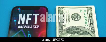 Banner NFT against money, logo of non fungible token and dollar bills on the office table, future of crypto art concep Stock Photo