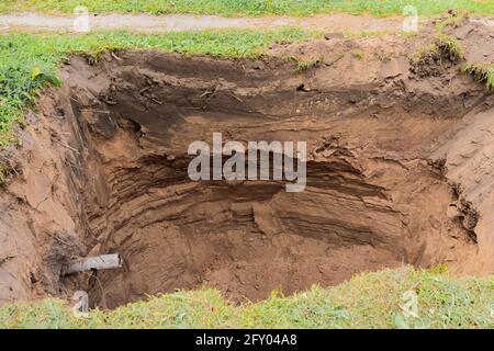 Deep pit in the ground for home sewers. Stock Photo