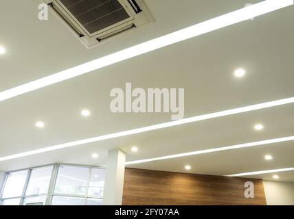 Lighting and ceiling mounted air conditioner on the modern office ceiling Stock Photo