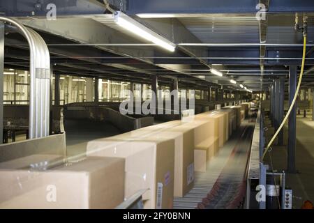Packages distributed on conveyor belt on automated system Stock Photo