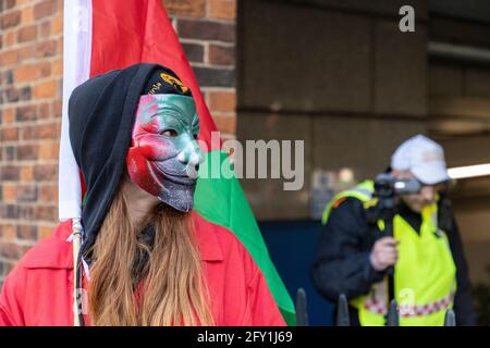 Protester in mask blocking police video camera with flag, Free Palestine Protest, Embassy of Israel, London, 22 May 2021 Stock Photo