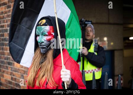 Protester in mask blocking police video camera with flag, Free Palestine Protest, Embassy of Israel, London, 22 May 2021 Stock Photo