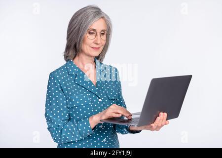 Photo portrait of senior lady typing using laptop working isolated on white color background Stock Photo